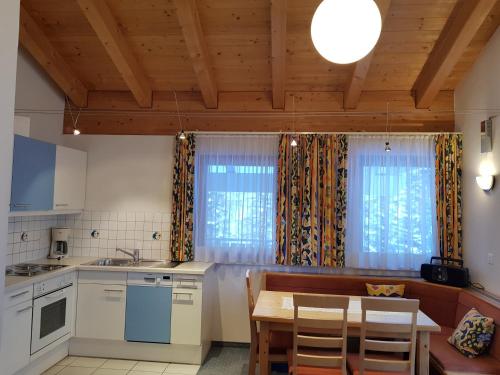 a kitchen with a table and a dining room at Apart Foresta in Samnaun