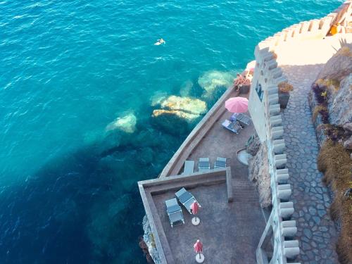 an aerial view of the ocean with chairs and umbrellas at Villa Scarpariello Relais in Ravello
