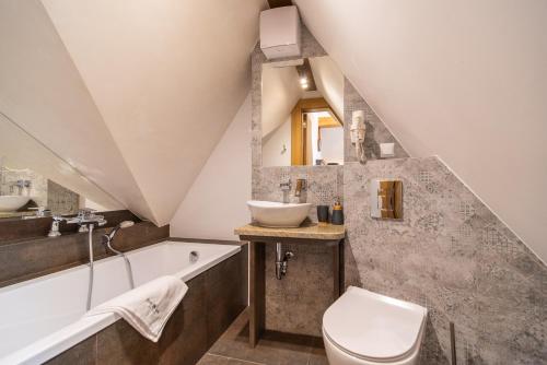 a bathroom with a sink and a toilet and a tub at Serce Tatr Residence Zakopane - blisko Krupówek in Zakopane