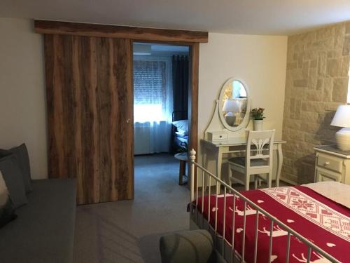 Schlafzimmer mit einem Bett, einem Schreibtisch und einem Spiegel in der Unterkunft Fewo Schönau am Königssee in Schönau am Königssee