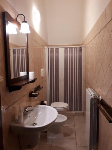 bagno con lavandino, servizi igienici e specchio di Masseria Cassiere a Mottola