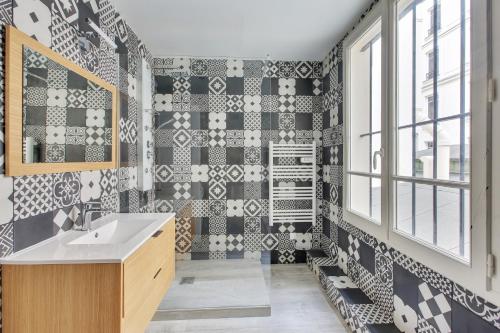 La salle de bains est revêtue de carrelage noir et blanc. dans l'établissement Suite KIMBERLEY, Great Flat, Montorgueil Paris, à Paris