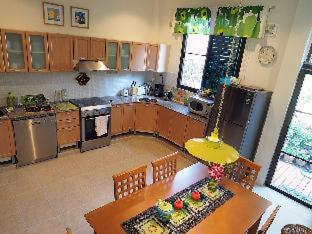 a kitchen with a table with a cake on it at Organgrinder Thai Paradise South in Cha Am