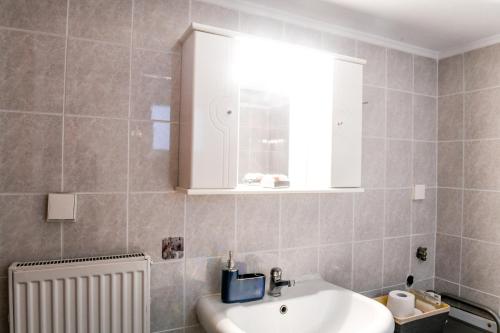 bagno con lavandino bianco e specchio di Papi's Free Parking Apartments 2 - 2 Bedroom a Alexandroupoli