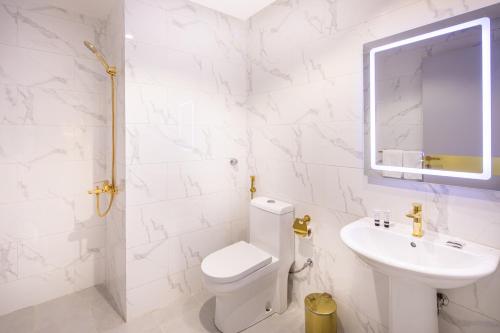 a white bathroom with a toilet and a sink at Kyona Al Qurayat - كيونا القريات in Jeddah