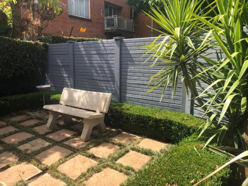 a bench sitting in the middle of a garden at Acacia Westdene B&B in Bloemfontein