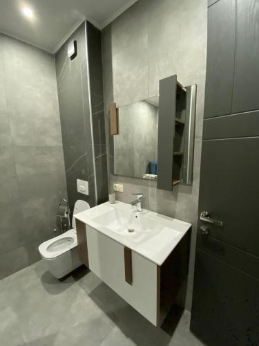 a bathroom with a white sink and a toilet at APARTMENT SIXTEEN in Tbilisi City