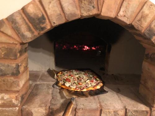 a pizza is cooking in a brick oven at Auksinio elnio slėnis in Rukliai