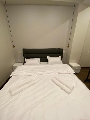 a large white bed with white sheets and pillows at APARTMENT SIXTEEN in Tbilisi City