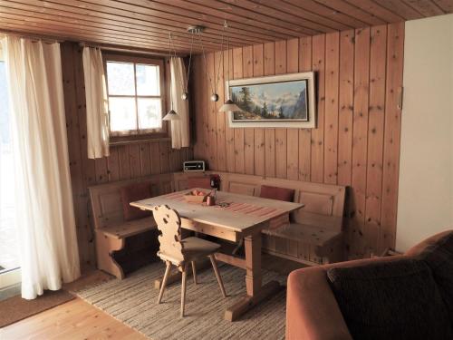 ein Esszimmer mit einem Holztisch und einem Fenster in der Unterkunft Chesa Sper l'Ovel Brail in Zernez