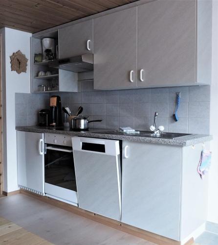 a kitchen with white cabinets and a sink at Chesa Sper l'Ovel Brail in Zernez