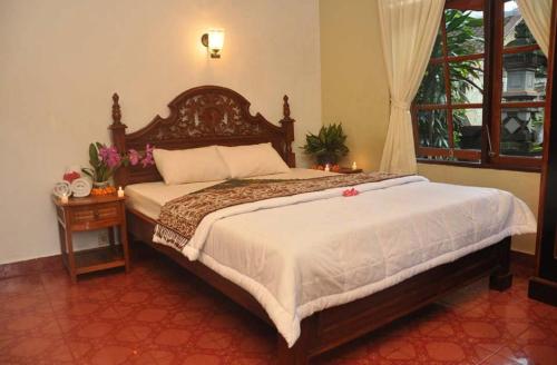 ein Schlafzimmer mit einem großen Bett und einem Fenster in der Unterkunft Candra Asri Bungalow in Ubud