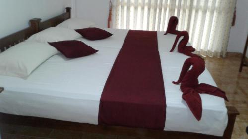 a bedroom with a large bed with two people on it at SA Village in Dambulla