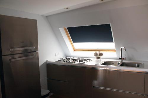 a kitchen with a stainless steel sink and a window at B&B Milu' in Crotone