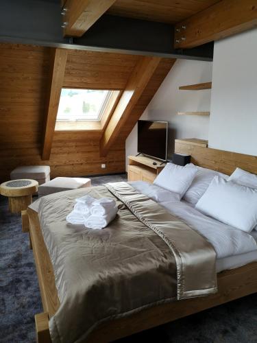 a bedroom with a large bed and a television at STONEGALLERY in Ždiar