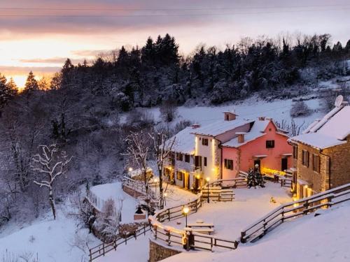 a house in the snow with lights on at Ongar Relax b&b in Bosco Chiesanuova