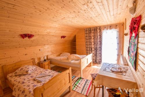 a bedroom with two beds in a wooden cabin at Cabana Ghetari in Gheţari
