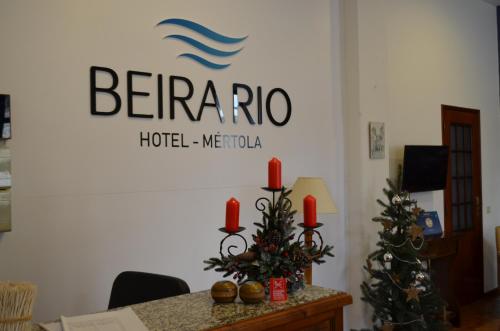 a room with a table with two christmas trees and a sign at Beira Rio in Mértola