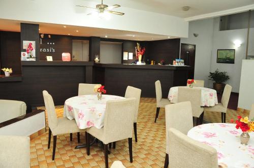 un ristorante con due tavoli e sedie con fiori di Hotel Frasi's a San Clemente del Tuyú