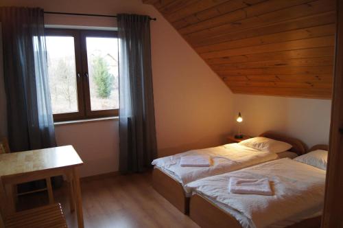 1 Schlafzimmer mit 2 Betten und einem Fenster in der Unterkunft Villa Dorka in Istebna