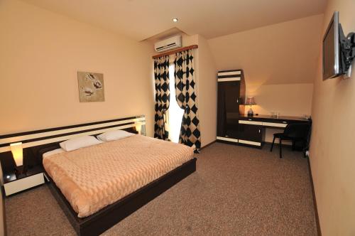 a bedroom with a bed and a desk and a computer at Hotel Diplomat in Tbilisi City