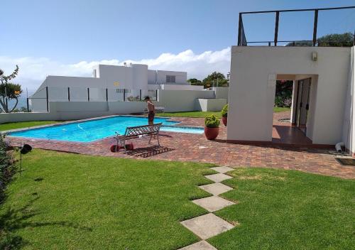 a man standing in front of a house with a pool at Arrowood 2 in Plettenberg Bay