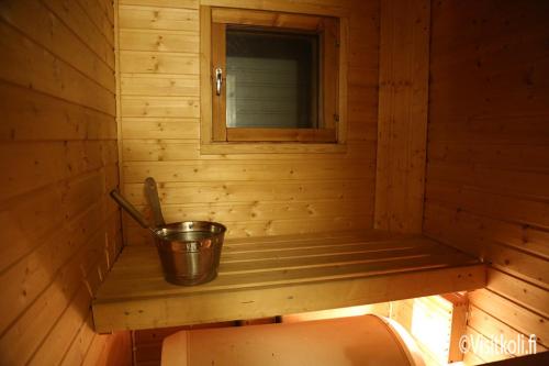 a small wooden sauna with a bucket on a shelf at Kolin Aada 2 in Kolinkylä