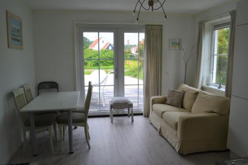 a living room with a couch and a table at Vakantiewoning aan duinen en zee in Dishoek in Dishoek