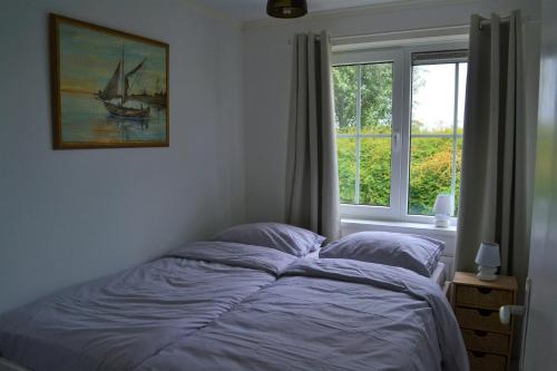 a bedroom with a bed and a window at Vakantiewoning aan duinen en zee in Dishoek in Dishoek