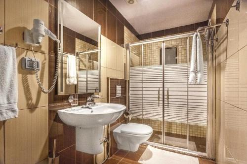 a bathroom with a sink and a toilet and a shower at Sofia Suites Hotel in Amman