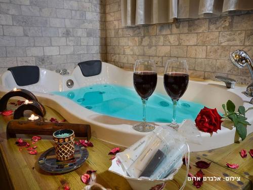 two glasses of wine sitting in a bath tub at צימרים טרה נוסטרה in Had Nes