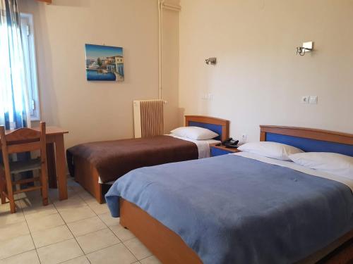 um quarto de hotel com duas camas e uma mesa em Hotel Ionion em Kyllini