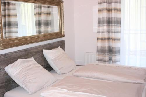 una camera da letto con 2 cuscini bianchi e uno specchio di APARTAMENT MANIA a Giżycko