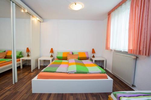 um quarto com uma cama com almofadas coloridas em Schöne Ferienwohnung am Schlosspark em Bad Brückenau