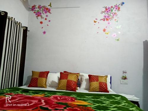 Khajuraho Dreams Homestay في خاجوراهو: غرفة نوم مع سرير مع زهور على الحائط