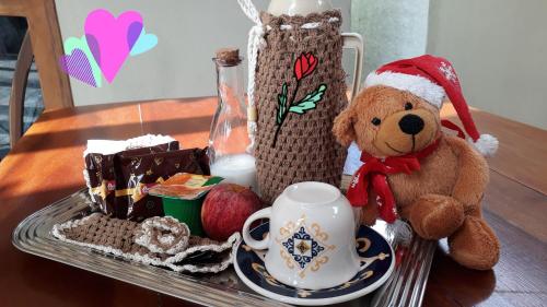 a teddy bear in a santa hat next to a tray of food at Pousada Kasabela Residence in Prea