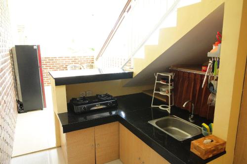 a small kitchen with a sink and a staircase at Na-Mi Guesthouse Canggu in Canggu