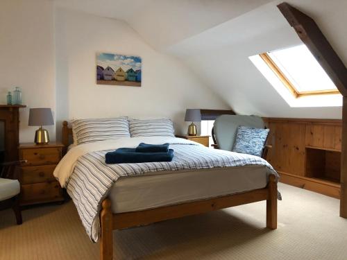 una camera da letto con un letto e una sedia in mansarda di Little Hilton Farm a Haverfordwest