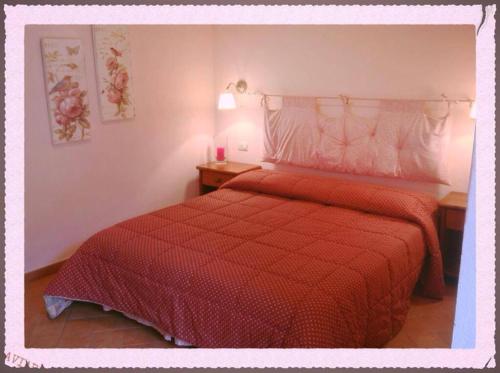 a bedroom with a red bed with a red comforter at Valle dei Mulini B&B in Marciana