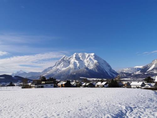 a snow covered mountain in front of a town at Apartment Fewo Irdning Pichlarn in Aigen im Ennstal