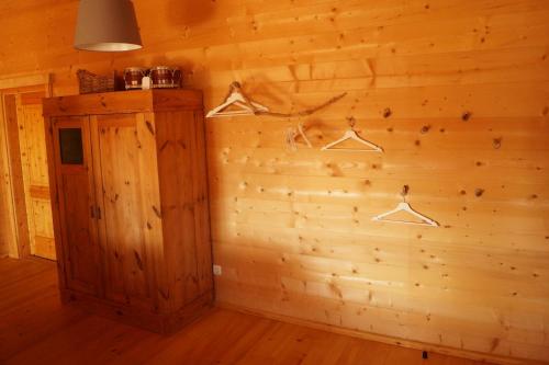 a room with a wooden wall with hangers at Ferienwohnung im gemütlichen Blockhaus vor den Bergen in Wielenbach