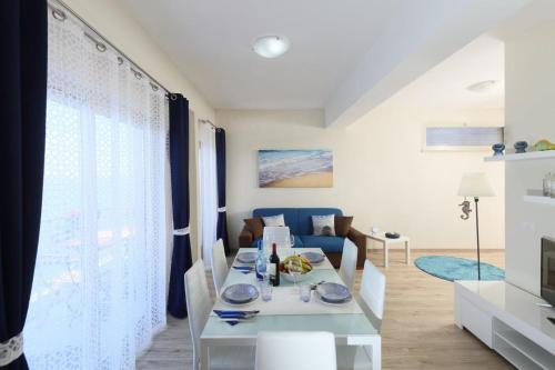 サンタ・テレーザ・ディ・リーヴァにあるIl Cavalluccio Marinoのリビングルーム(白いテーブル、青いソファ付)