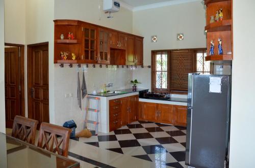 a kitchen with wooden cabinets and a black refrigerator at Villa Ditya - Luxury villa near Yogyakarta in Klaten
