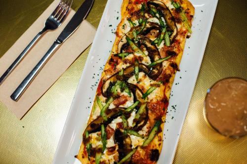 a pizza on a white plate on a table at Pangea Pod Hotel in Whistler