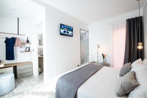 een witte slaapkamer met een bed en een bureau bij Benaco36 in Torri del Benaco