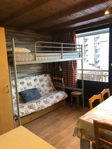 a bunk bed in a room with a couch and a table at Residence Le Lac Blanc in Val Thorens
