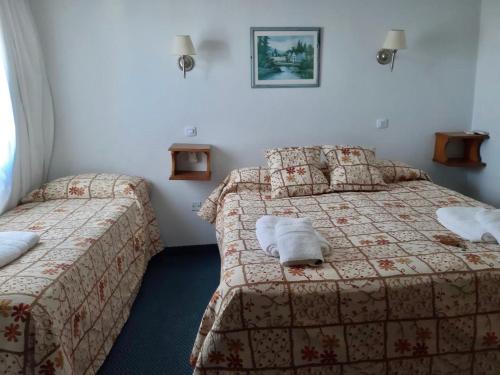 una camera d'albergo con due letti con asciugamani sopra di Hotel Frasi's a San Clemente del Tuyú