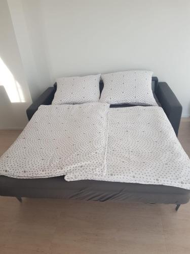 ein Bett mit zwei Kissen darüber in der Unterkunft 50 Quadratmeter abgeschlossene Wohnung mit Panoramablick in Pfaffenhofen an der Ilm