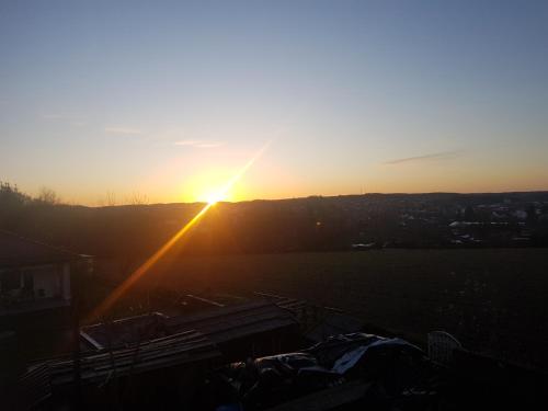 a sunset over a field with the sun setting at 50 Quadratmeter abgeschlossene Wohnung mit Panoramablick in Pfaffenhofen an der Ilm