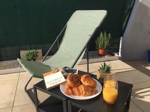 - un plateau de viennoiseries sur une table avec une plaque de jus d'orange dans l'établissement Bord de mer, studio avec terrasse, à Villeneuve-Loubet